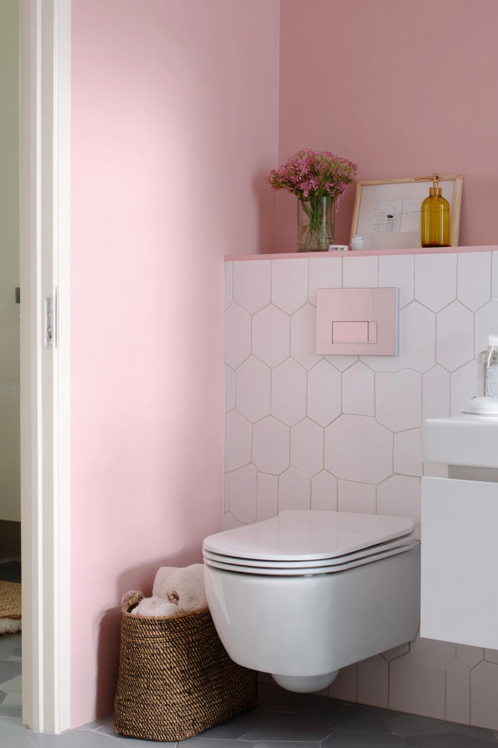7. Toilet inspiratie met pastelroze muurverf en witte hexagon tegels